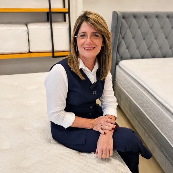 Cama box com cabeceira cinza capitonê exposta na Casa dos Colchões